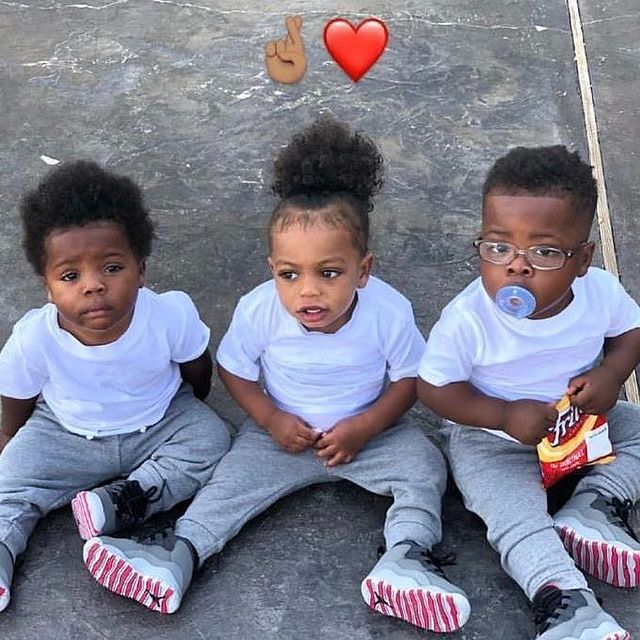 Kamiri Gaulden posing in a white t-shirt and grey pant with his siblings.
